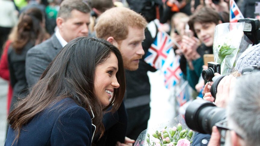 Britain’s Prince Harry and his fiancee Meghan Markle greet the public at an event