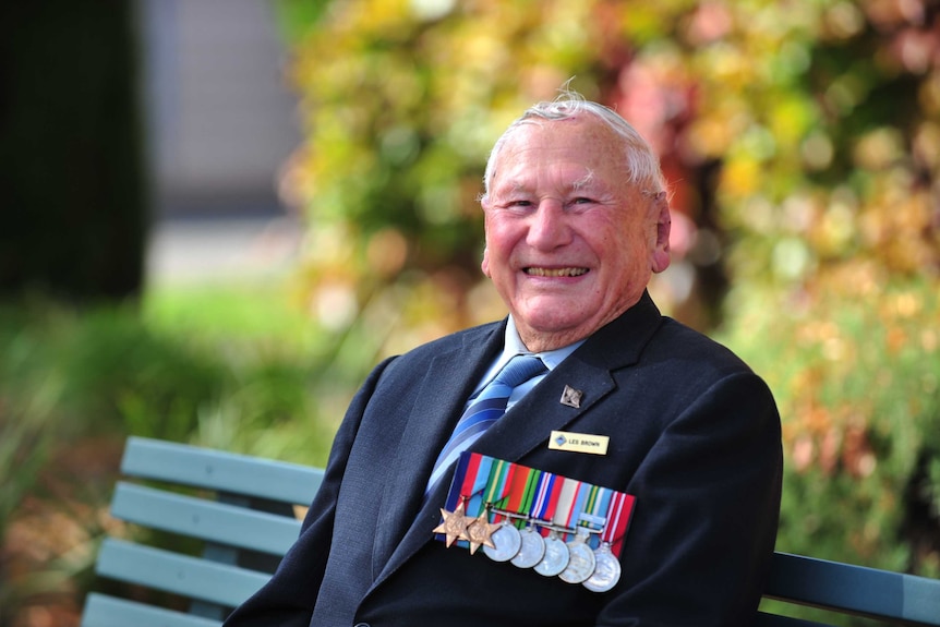 World War Two veteran Les Brown sits outside wearing his service medals ahead of Anzac Day 2020.