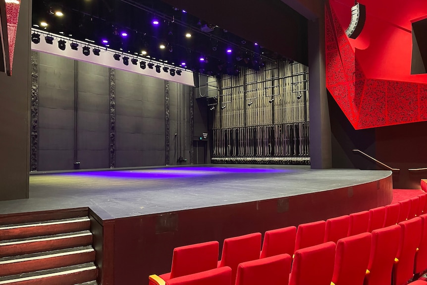 Large theater stage with red curtains and lights