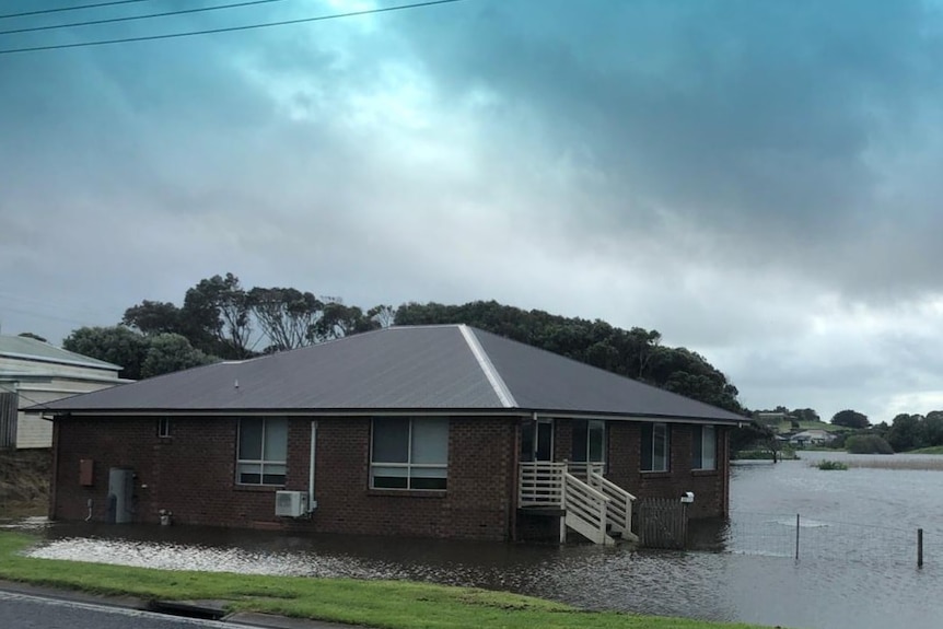 Water surrounds a house in a suburban area.