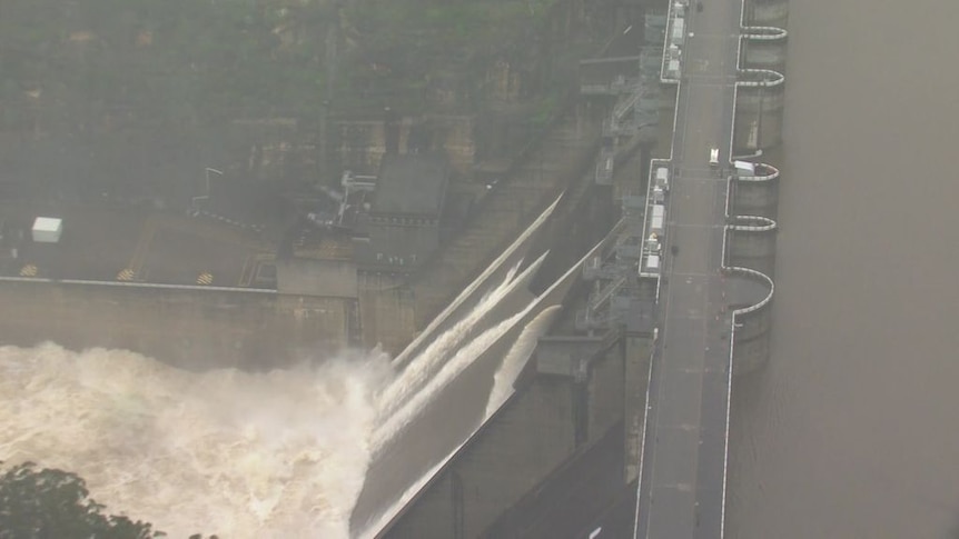 An aerial shot of water gushing over a dam.