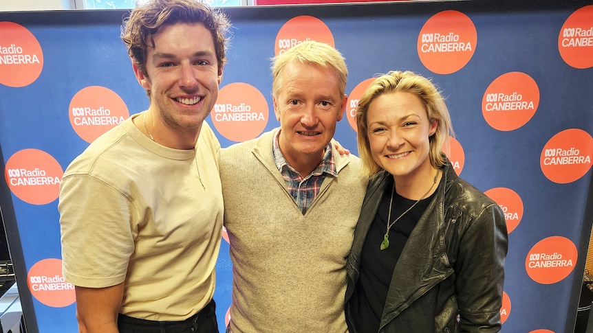 Three smiling people in a radio studio