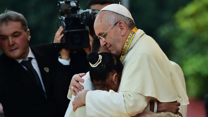Pope Francis embraces three children in Manila