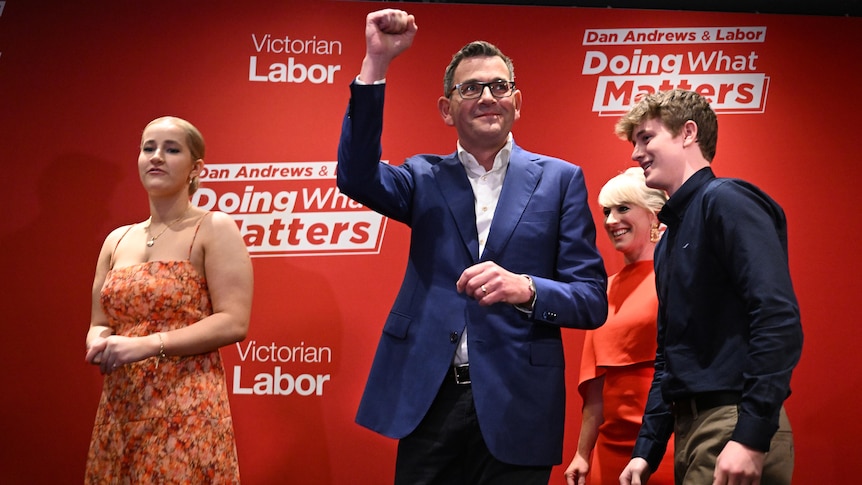 Victorian Premier Daniel Andrews punches the air, surrounded by his wife and two adult children.