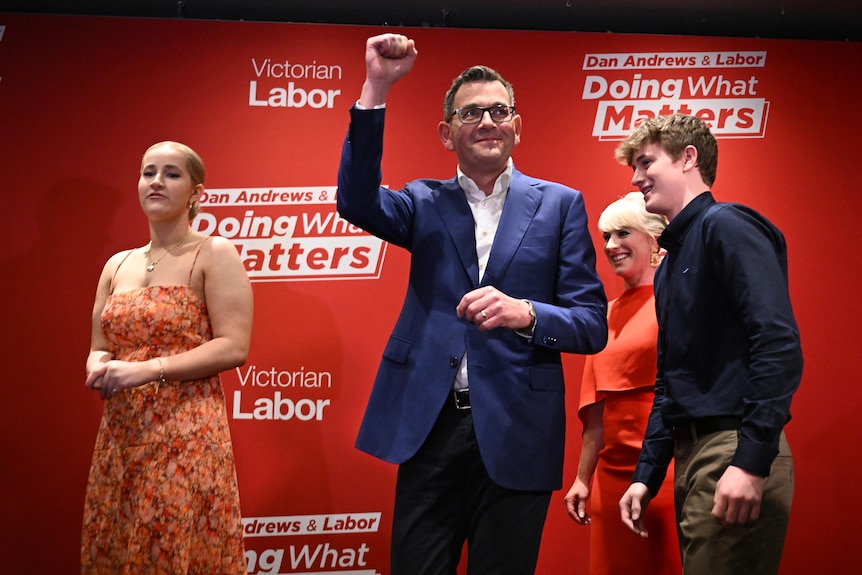 Victorian Premier Daniel Andrews punches the air, surrounded by his wife and two adult children.
