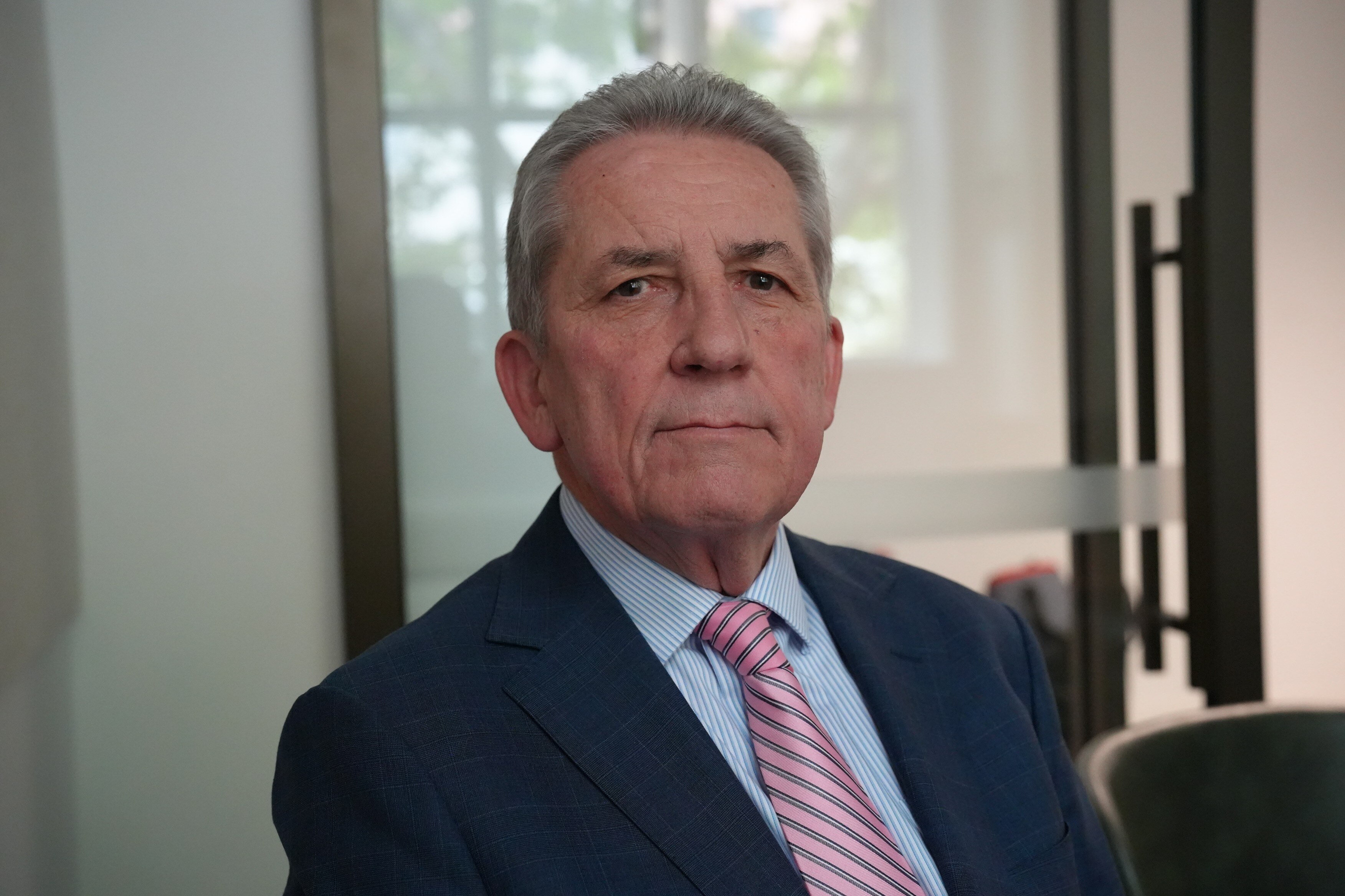 Chris Evans wearing navy suit, blue shirt and pink striped tie