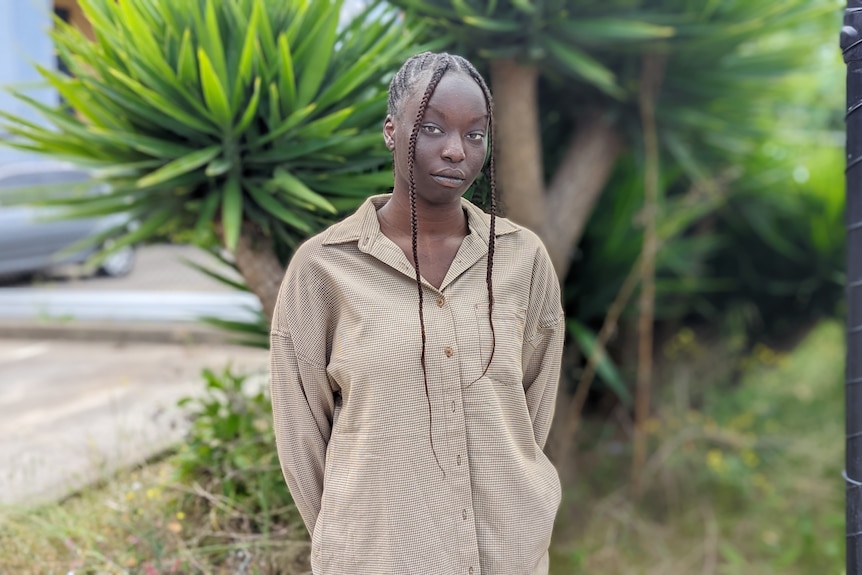 A young woman looks at the camera.