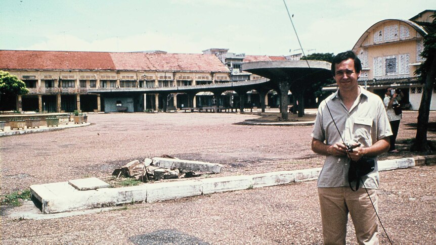 A faded photo from the 70s shows a man standing in front of an abandoned market.
