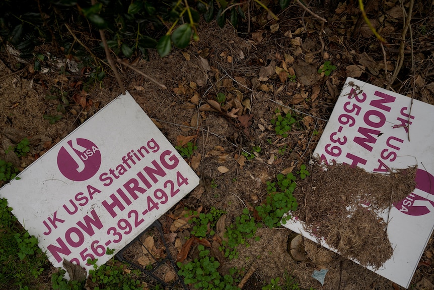 Signs are seen discarded at the former location of JK USA Staffing in Alexander City, Alabama