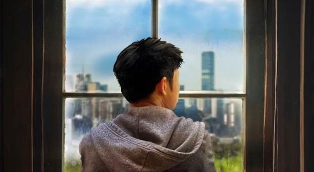 An illustration of a boy staring out a window from behind. 