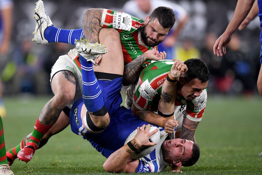 Rugby League player tackling an opposition player during a match.