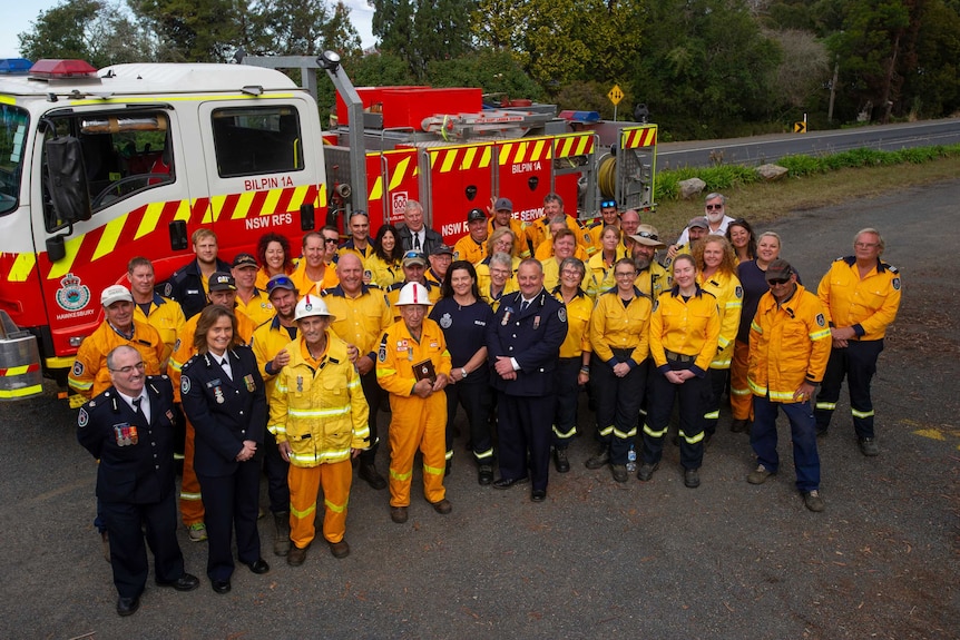 The Bilpin RFS brigade stand in front of a fire truck.