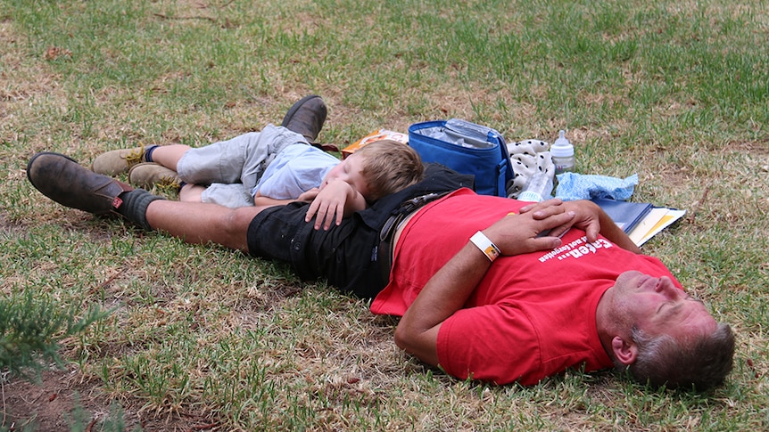 A man and his son take a nap at WOMADelaide