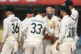 A group of Australian male Test cricketers come together as they celebrate a wicket against India.