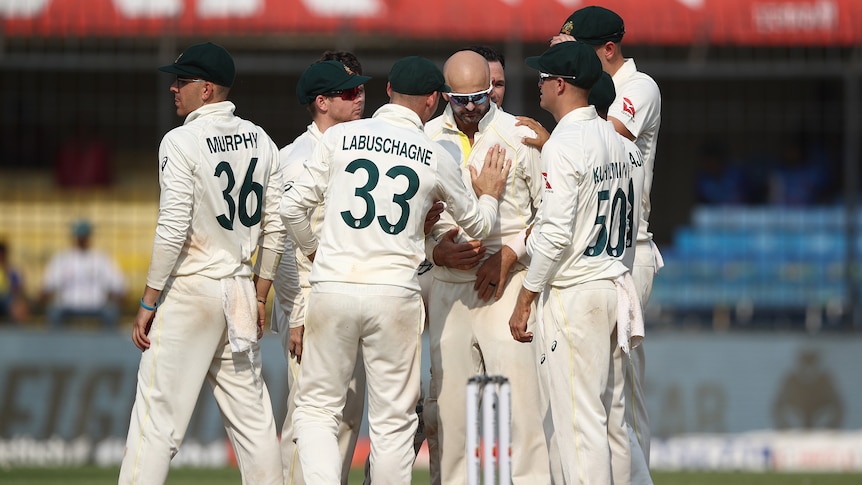 A group of Australian male Test cricketers come together as they celebrate a wicket against India.