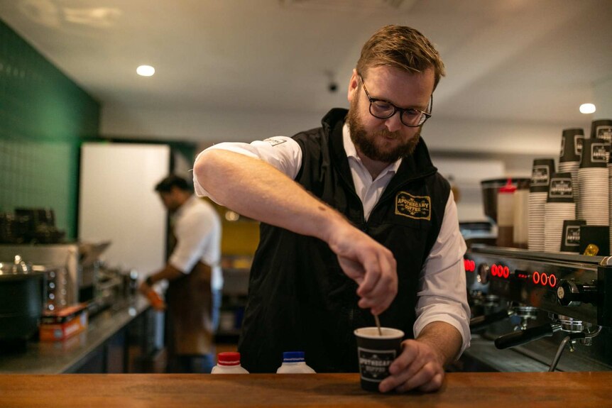 a man preparing a coffee in a cafe