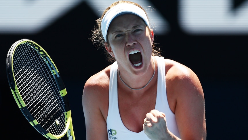 An American female tennis player screams out as she celebrates winning a point.