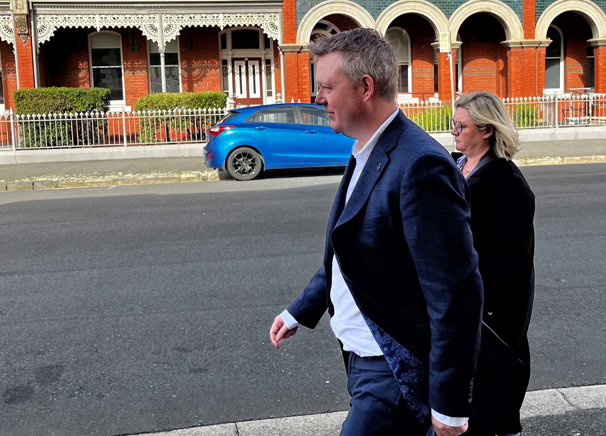 James Redmond Burrows walking in a city street.
