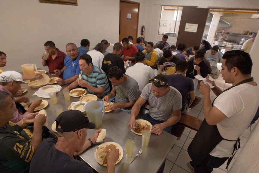 Men at the Casa de Migrante shelter in Tijuana have a meal.