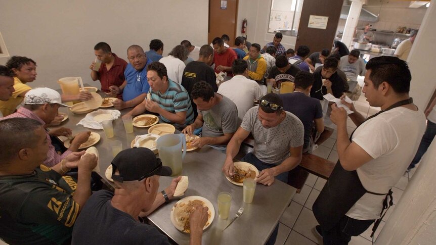 Men at the Casa de Migrante shelter in Tijuana have a meal.