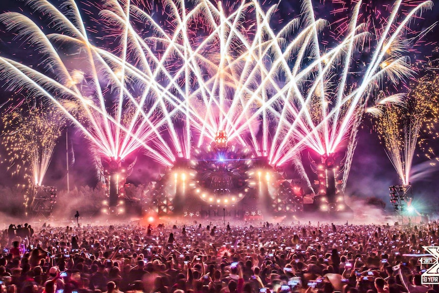 Huge crowds of people in front of a stage at a music festival