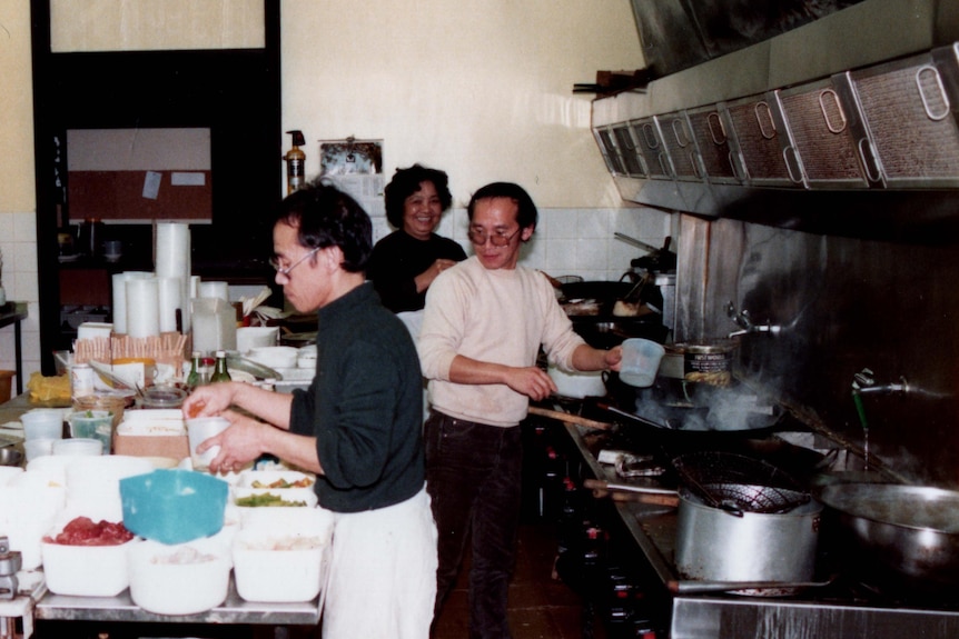 A group of chefs inside a restaurant kitchen.