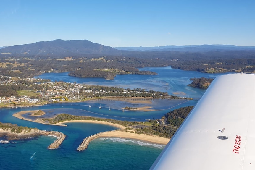 An aerial view of Narooma with a wing-tip. 