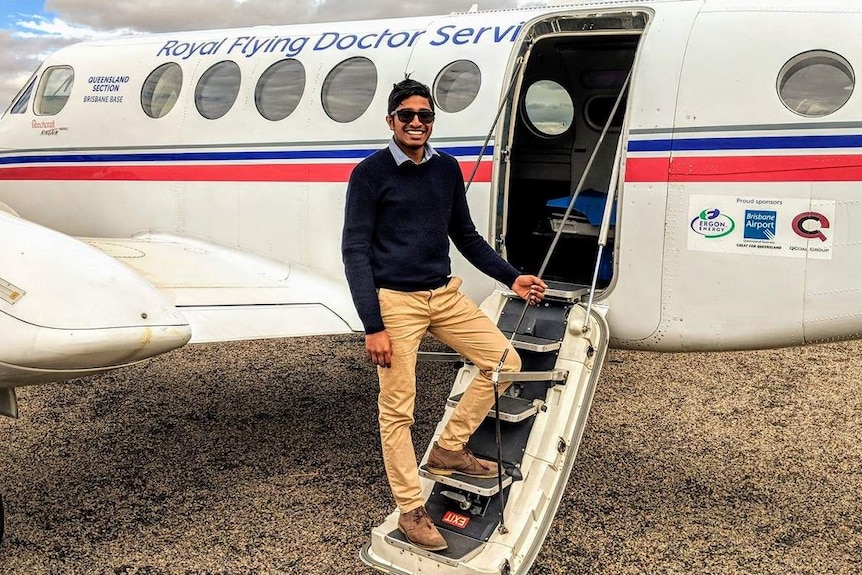 Man stands on steps of aircraft