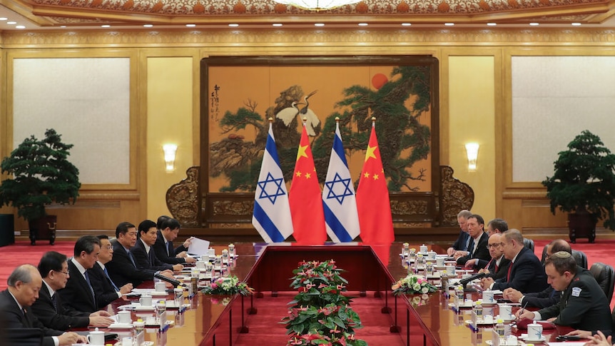 China and Israel leaders at a large meeting table, with the flags of both countries in the middle