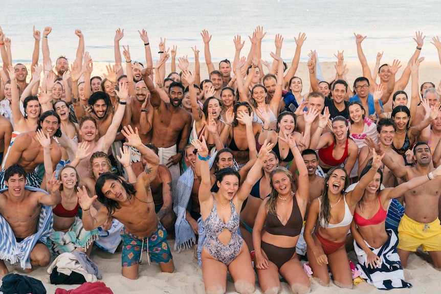 A group of young people posing for a photo on a beach