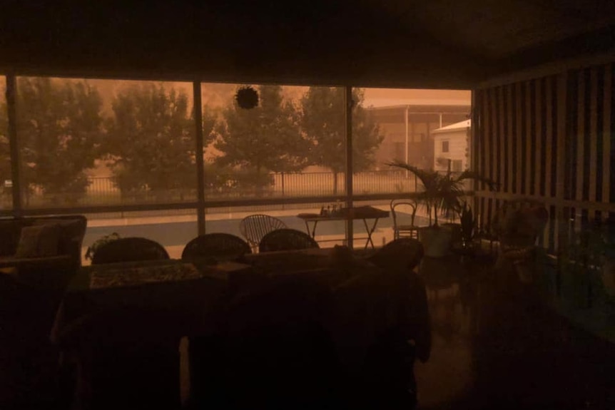 dust storm outside darkens room and sweeping over an outdoor pool