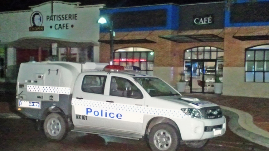 TV still of police car at Joondalup carpark at night where two men were stabbed on 7th of August 2011