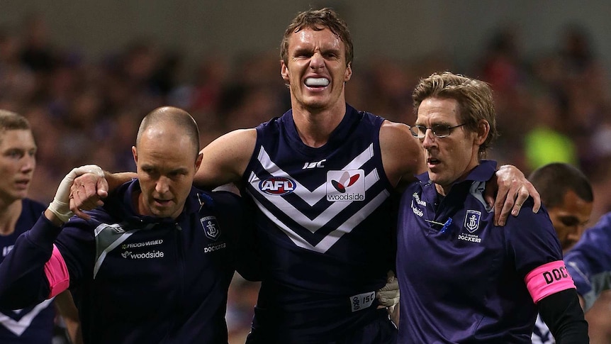 Fremantle's Jonathon Griffin is helped from the field after injuring his knee against Collingwood.