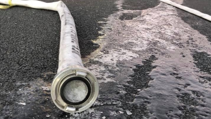 A frozen hose in front of a fire truck