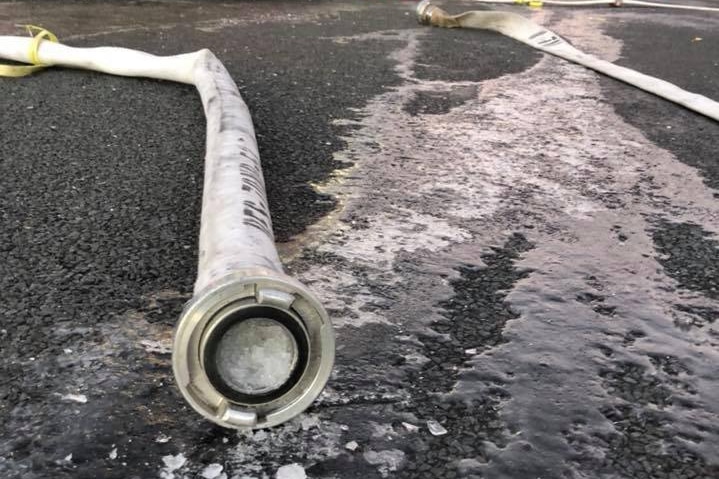 A frozen hose in front of a fire truck