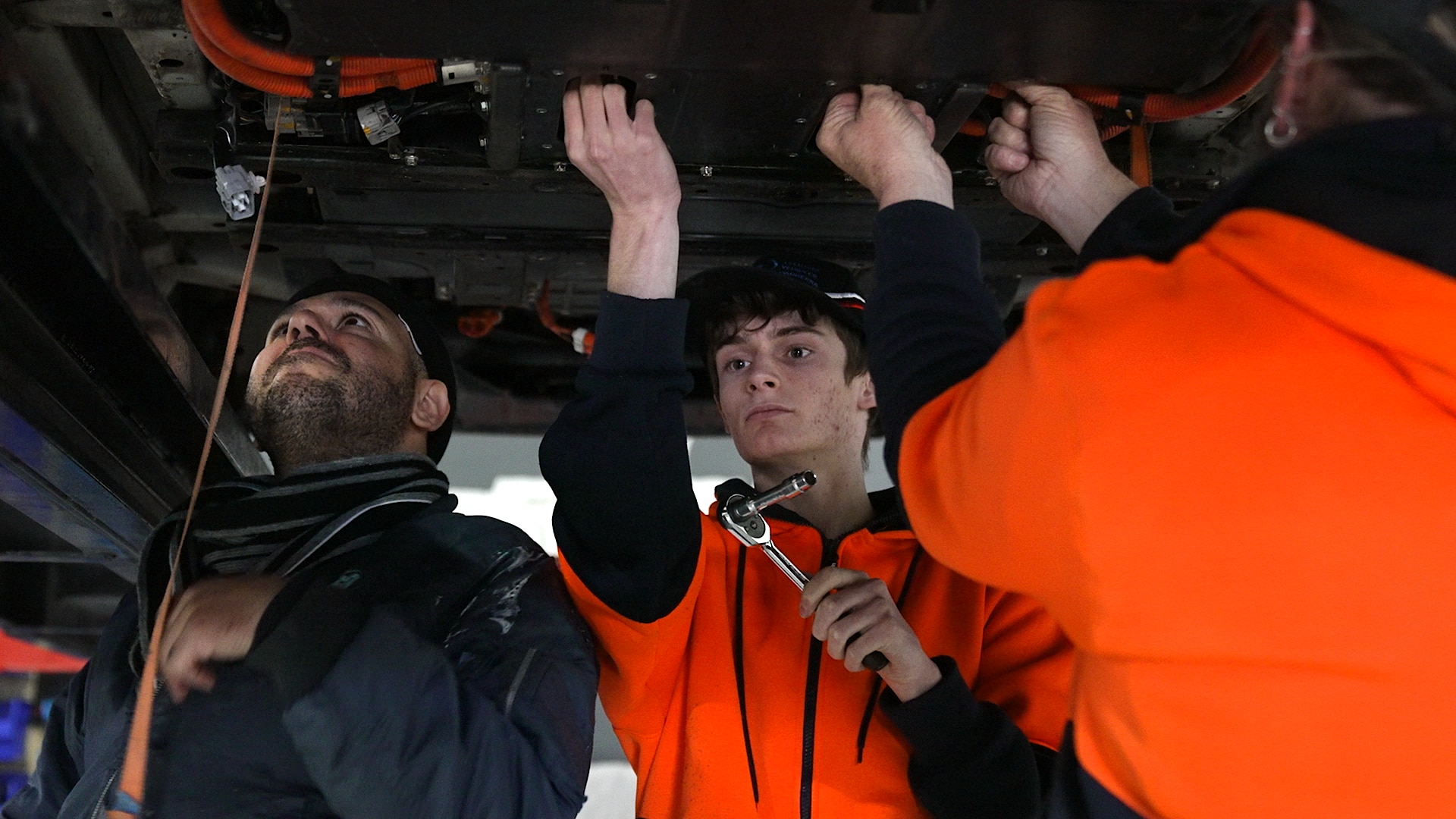 Mr Hemmingsen's apprentices help replace the battery of an EV.