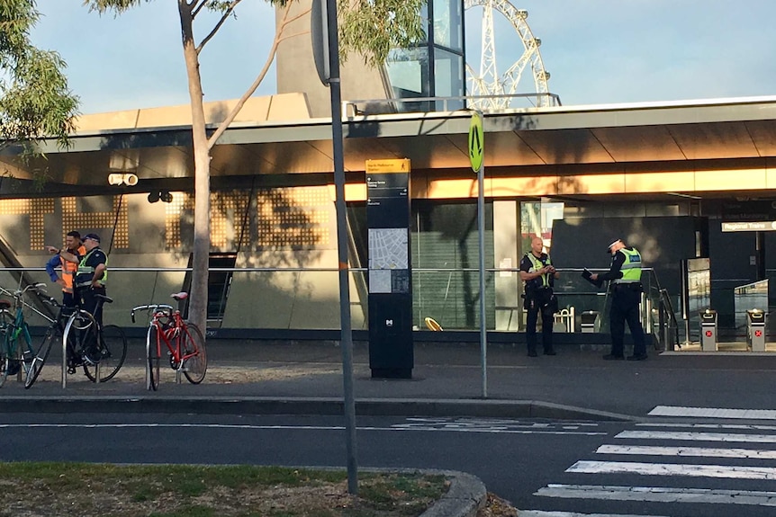 Police officers stand outside North Melbourne station.