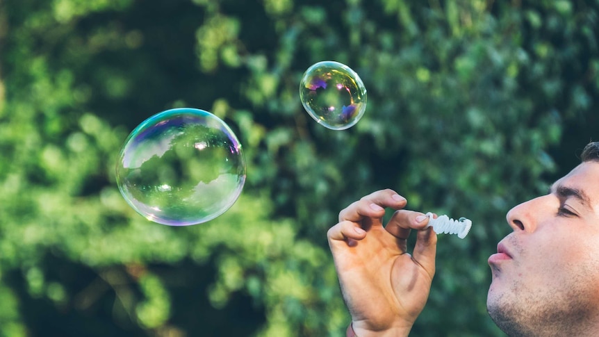 A man blows some bubbles into the air