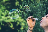 A man blows some bubbles into the air