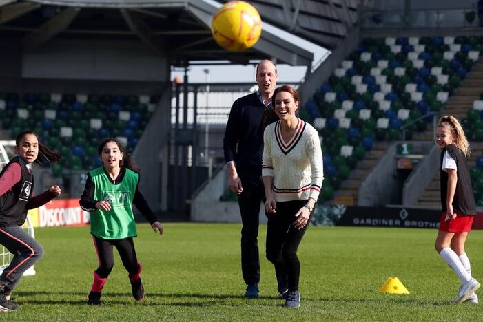 Kate, second from right, next to William, left, who has two kids to the left of him, while one is to right of Kate, on field.