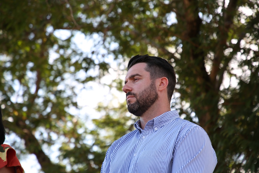 Fannie Bay by-election Labor candidate Brent Potter standing under a tree on a sunny day, looking serious.