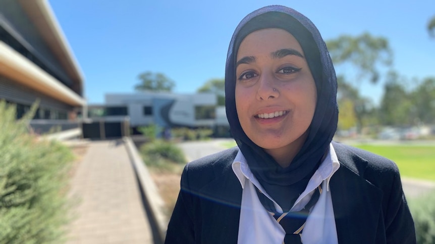 A student stands outside her school ahead of a planned strike for action on climate change