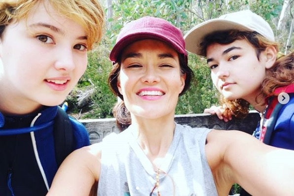 Yumi takes a selfie with two of her children on a hike