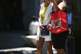 Cropped shot of two women carrying Christmas shopping bags.