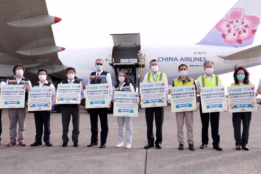 Taiwan health officials hold up cards thanking the US for the COVID-19 vaccines