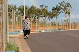 Linda Hyland walking her dog next to a long row of fences.