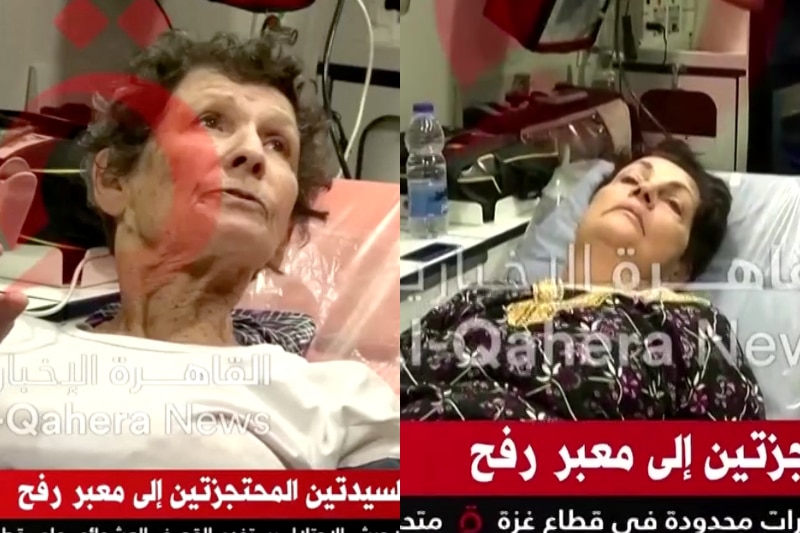 A video still overlaid with watermarks shows two elderly women lying in ambulance beds.