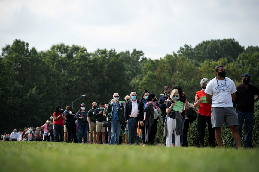 People wait in a socially distant line at an early voting site at the Fairfax County Government Center in Fairfa