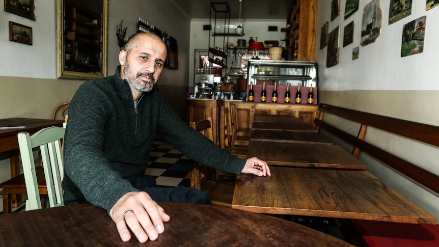 Castlemaine cafe owner, Italian born Luca Sartori sitting in his empty cafe.