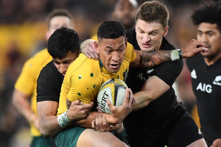 Wallabies' Israel Folau tackled by All Blacks' Rieko Ioane and Beauden Barrett during game one of the Bledisloe Cup, 2017